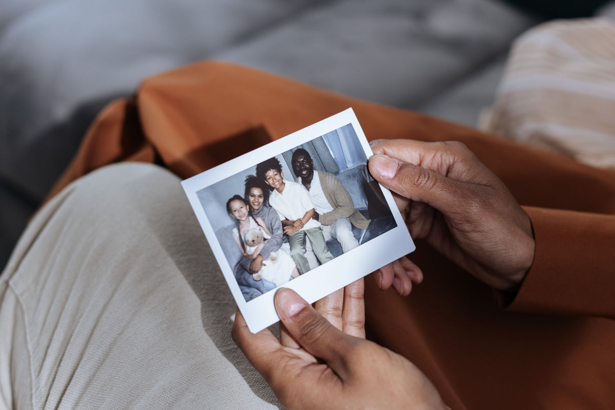 Hands holding a printed family photograph as a keepsake
