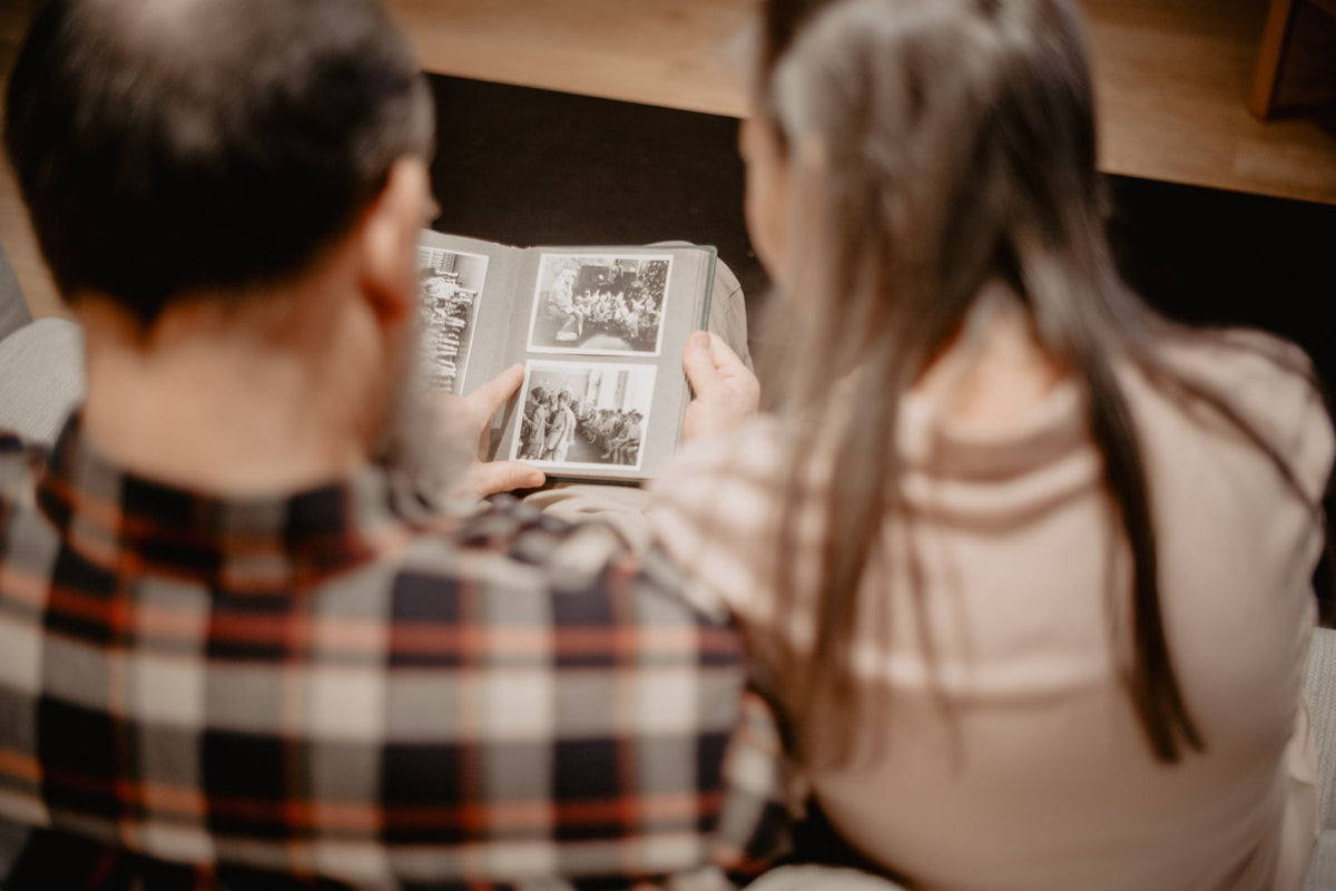 Two people looking through a family photo album together
