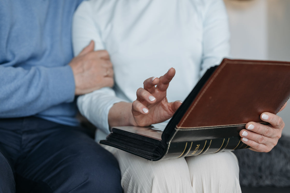 Two people sharing a quiet moment with a photo album